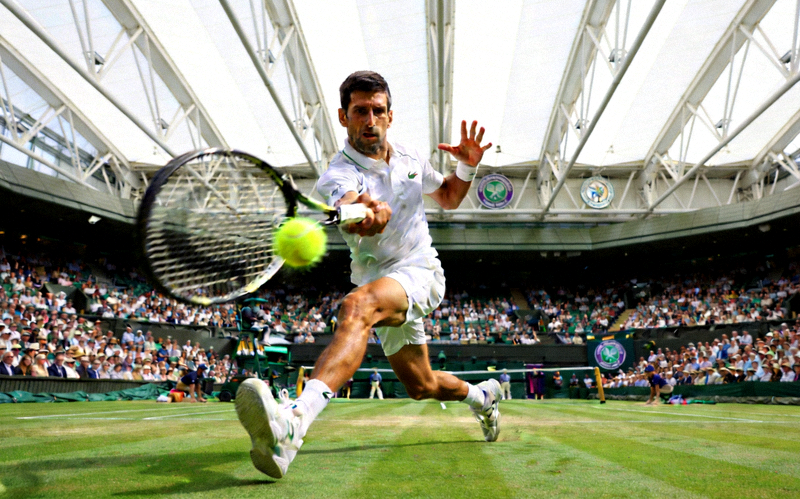 温布尔登网球锦标赛高清图片 - 选手在草地上奋力挥拍击球的优雅姿态