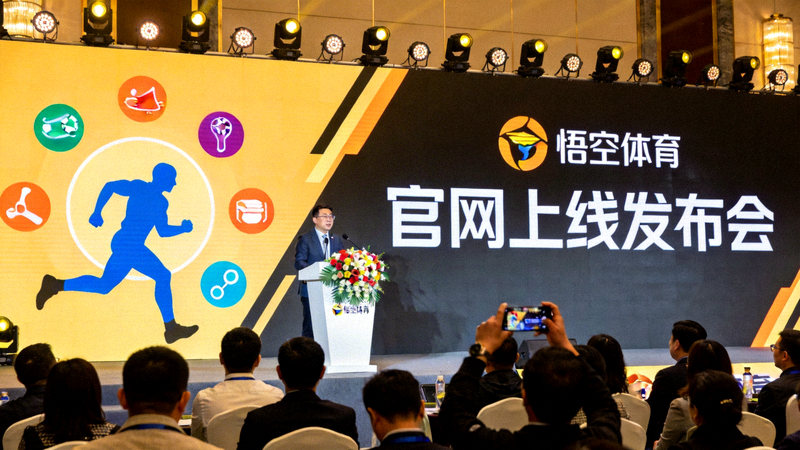 悟空体育官网上线发布会现场，背景是巨大的体育主题背景板