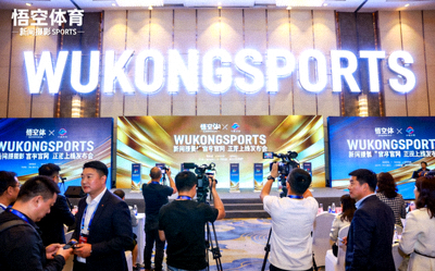 悟空体育官网正式上线发布会现场照片，背景是巨大的WUKONGSPORTS发光Logo